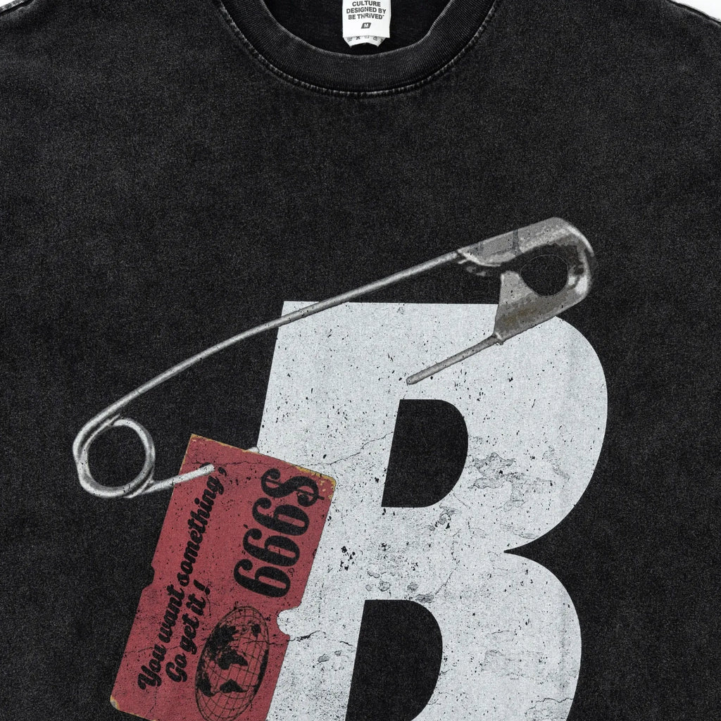 Black sweatshirt with a large white letter 'B' and safety pin graphic on a dark background