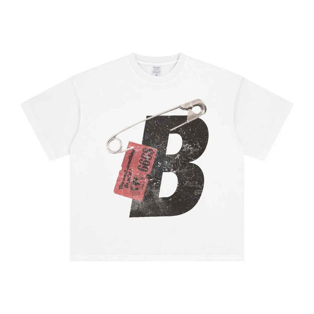 White t-shirt with a large black letter 'B' and a safety pin attached, on a white background
