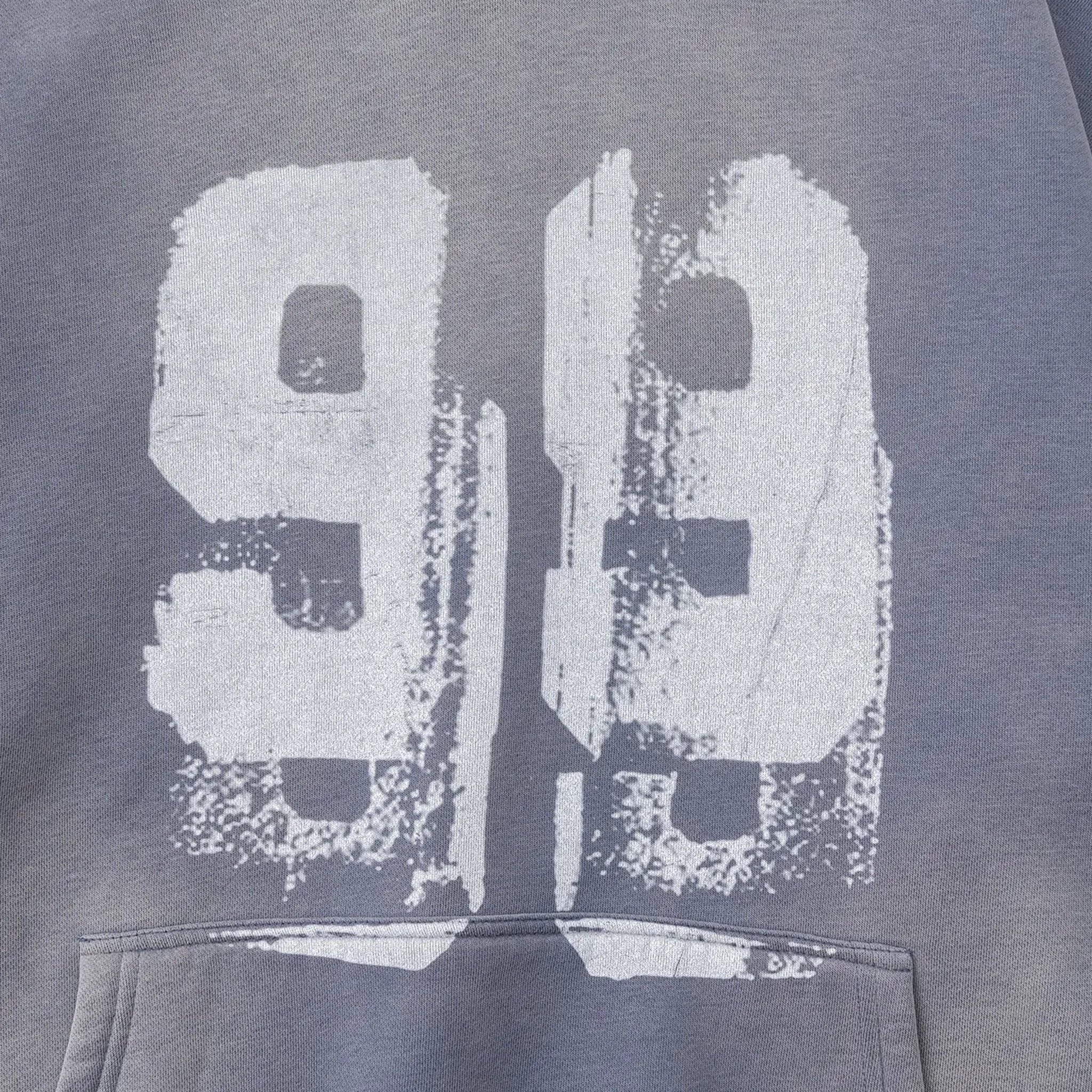 Gray sweatshirt with large white number '99' print on a dark background