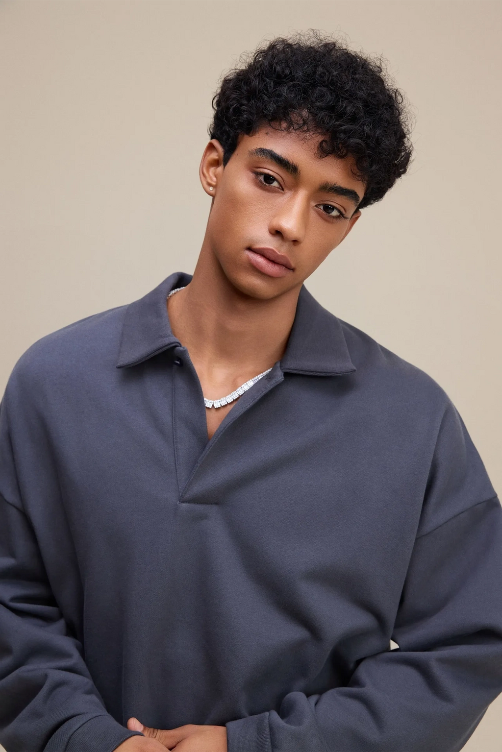 Person wearing a dark blue pullover against a beige background