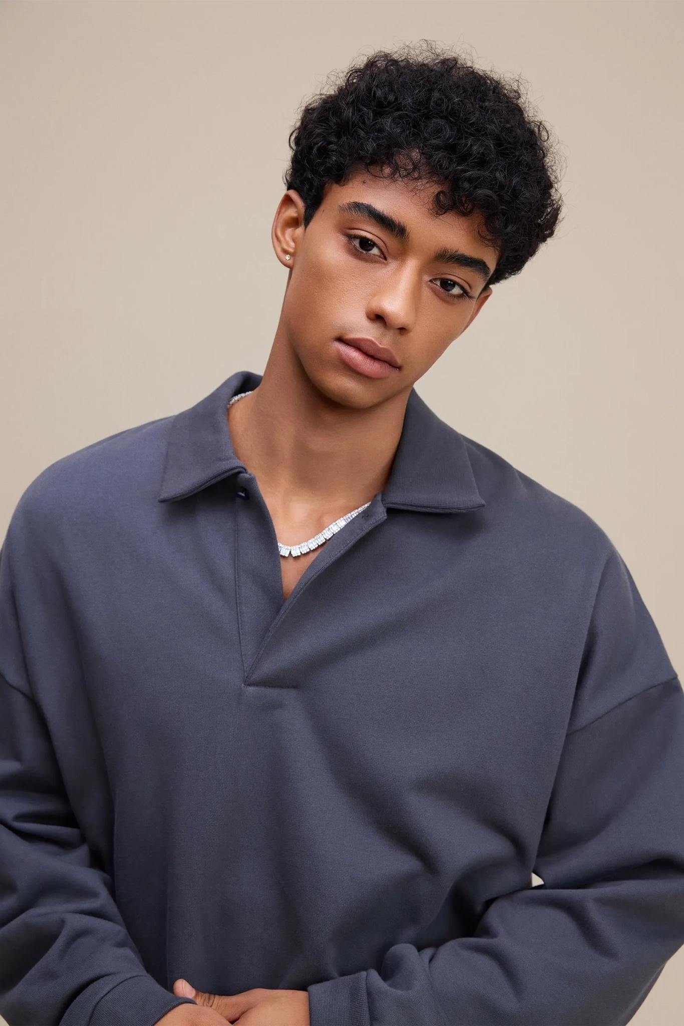 Person wearing a dark blue pullover against a beige background