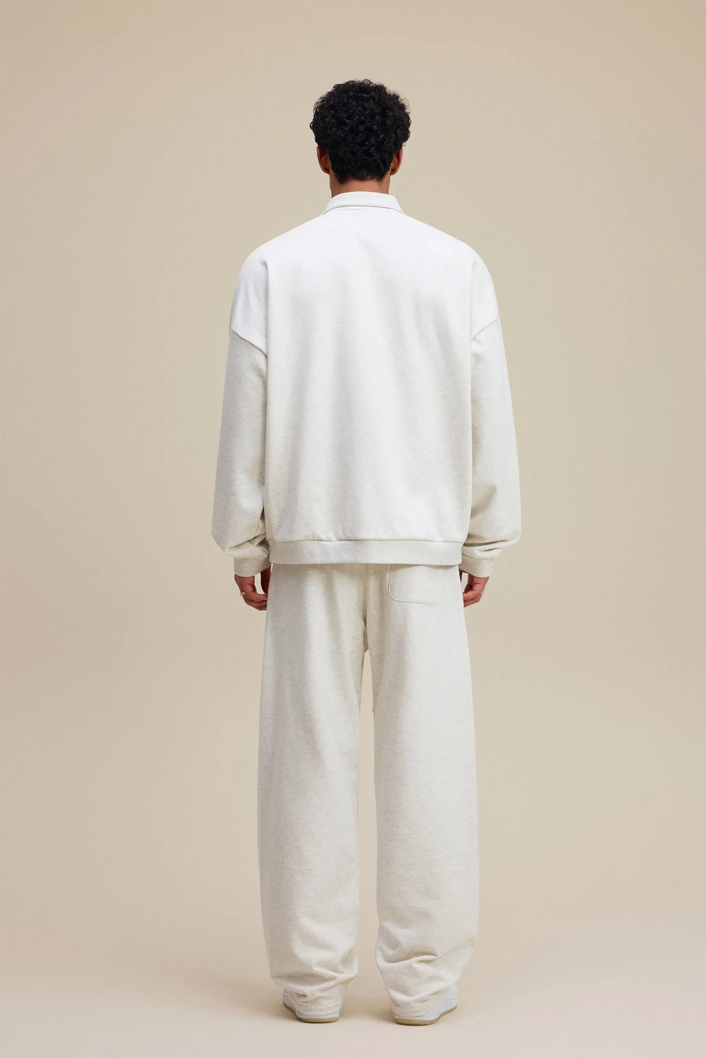 Person wearing a white outfit on a beige background