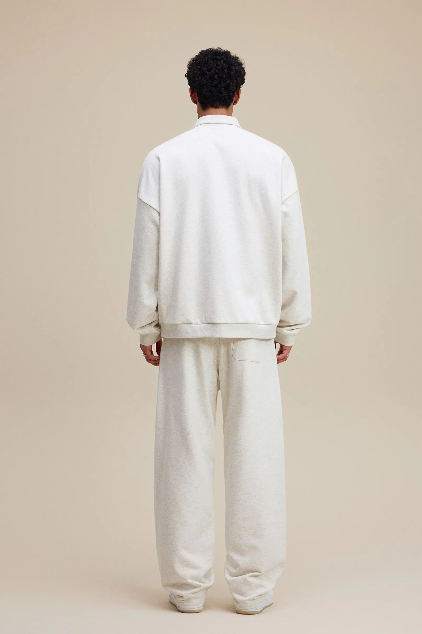 Person wearing a white outfit on a beige background