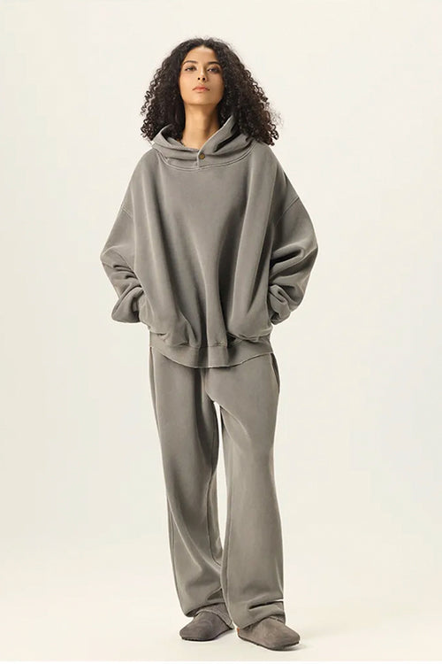 Person wearing a gray hoodie and pants on a white background