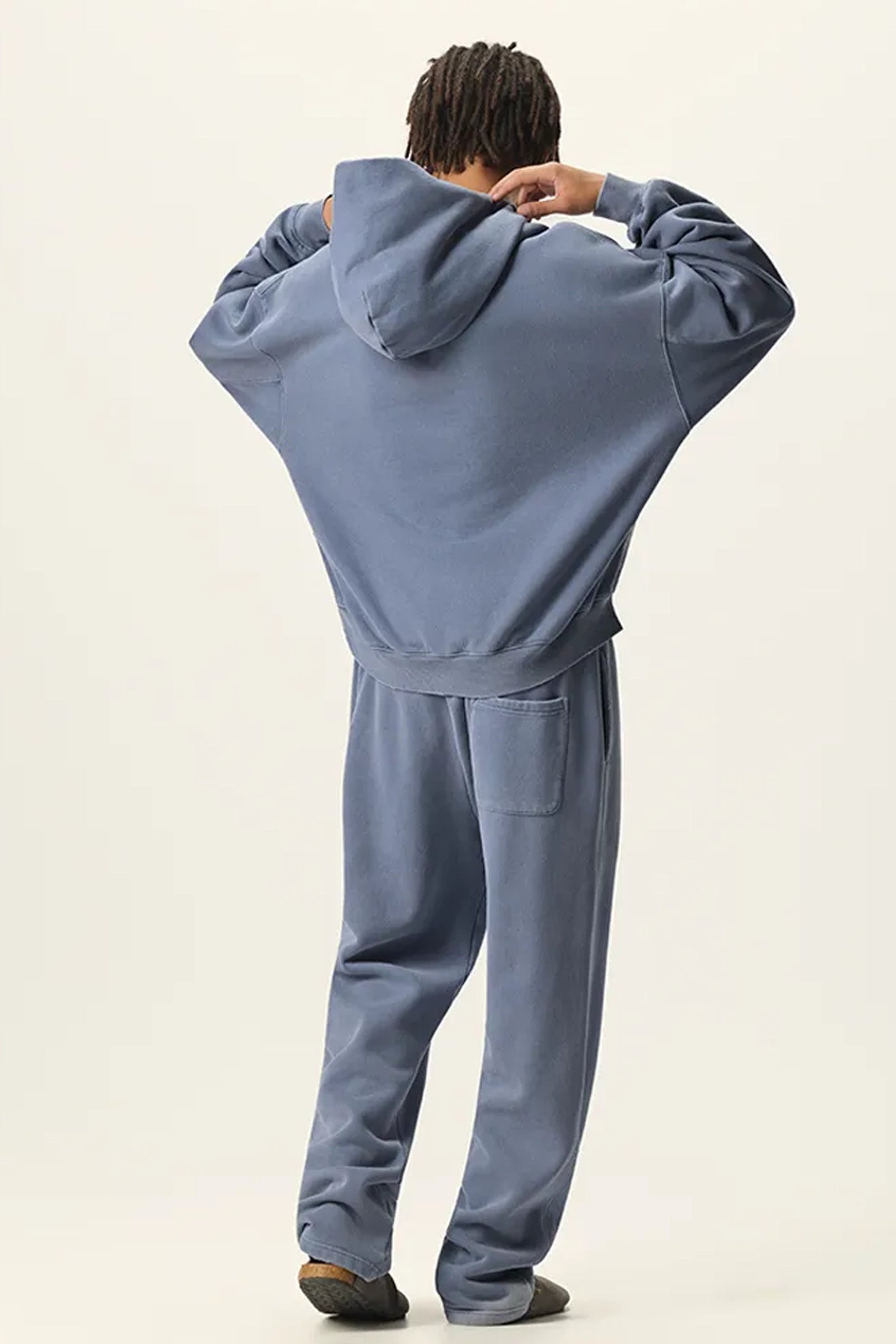 Person wearing a blue tracksuit against a white background