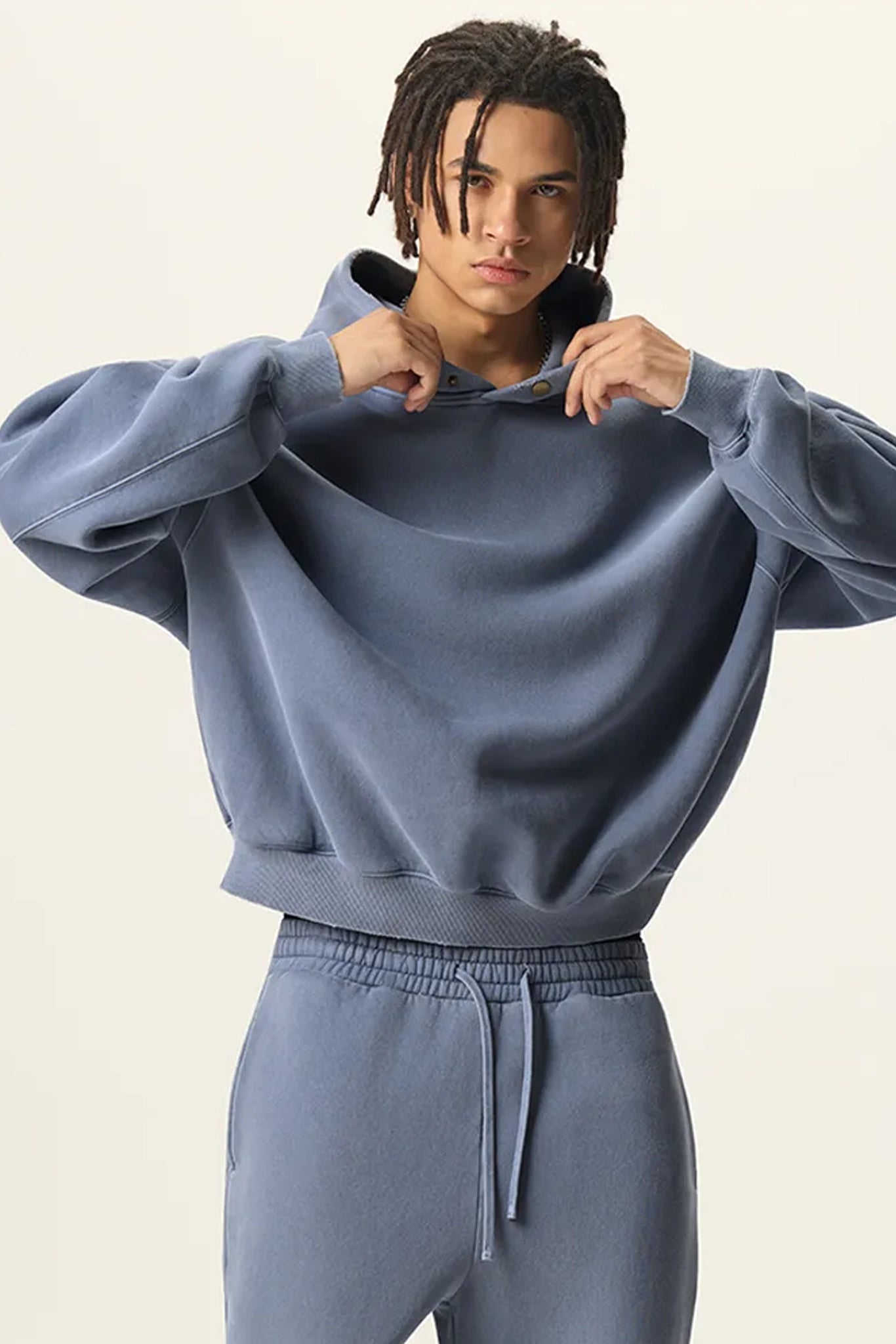 Person wearing a blue tracksuit against a plain background