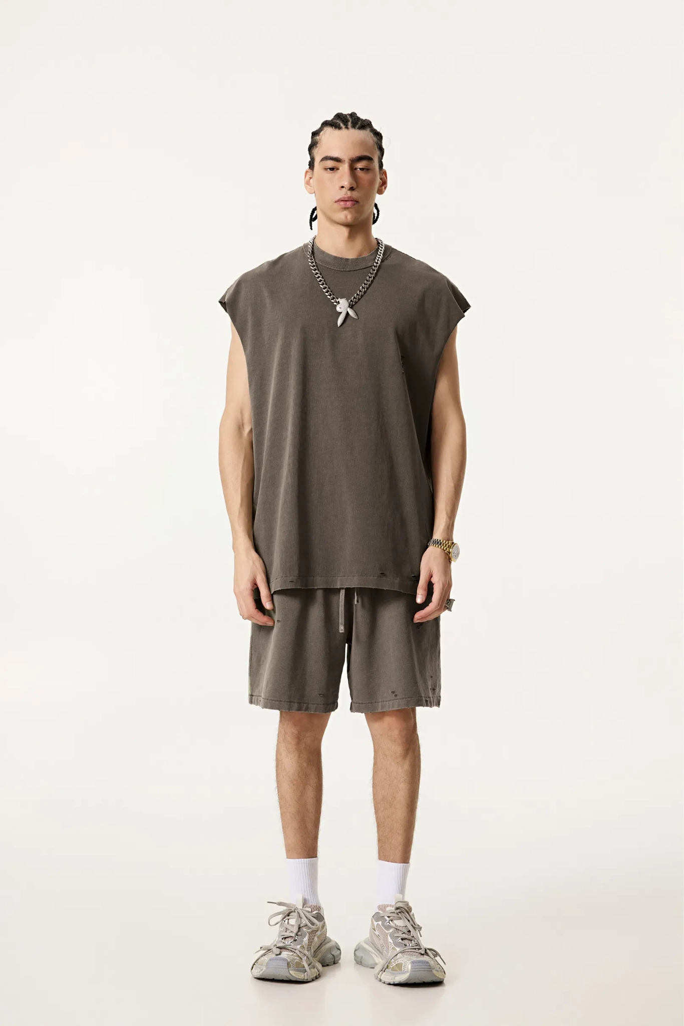 Person wearing a sleeveless brown top and shorts on a white background