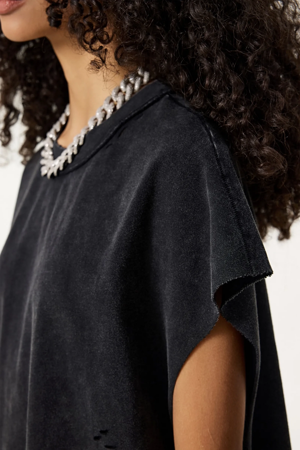 Person wearing a black top with a white background