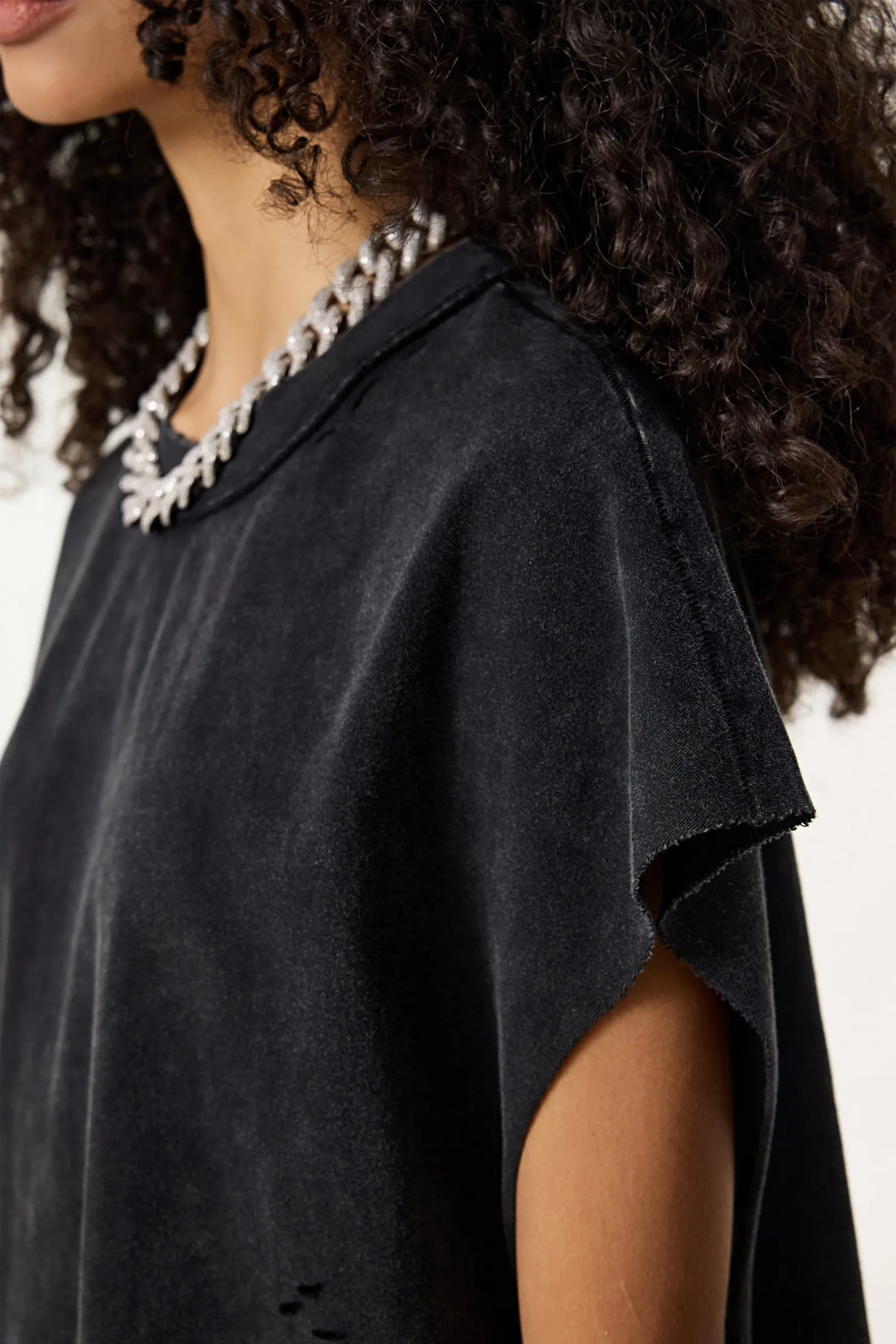 Person wearing a black top with a white background