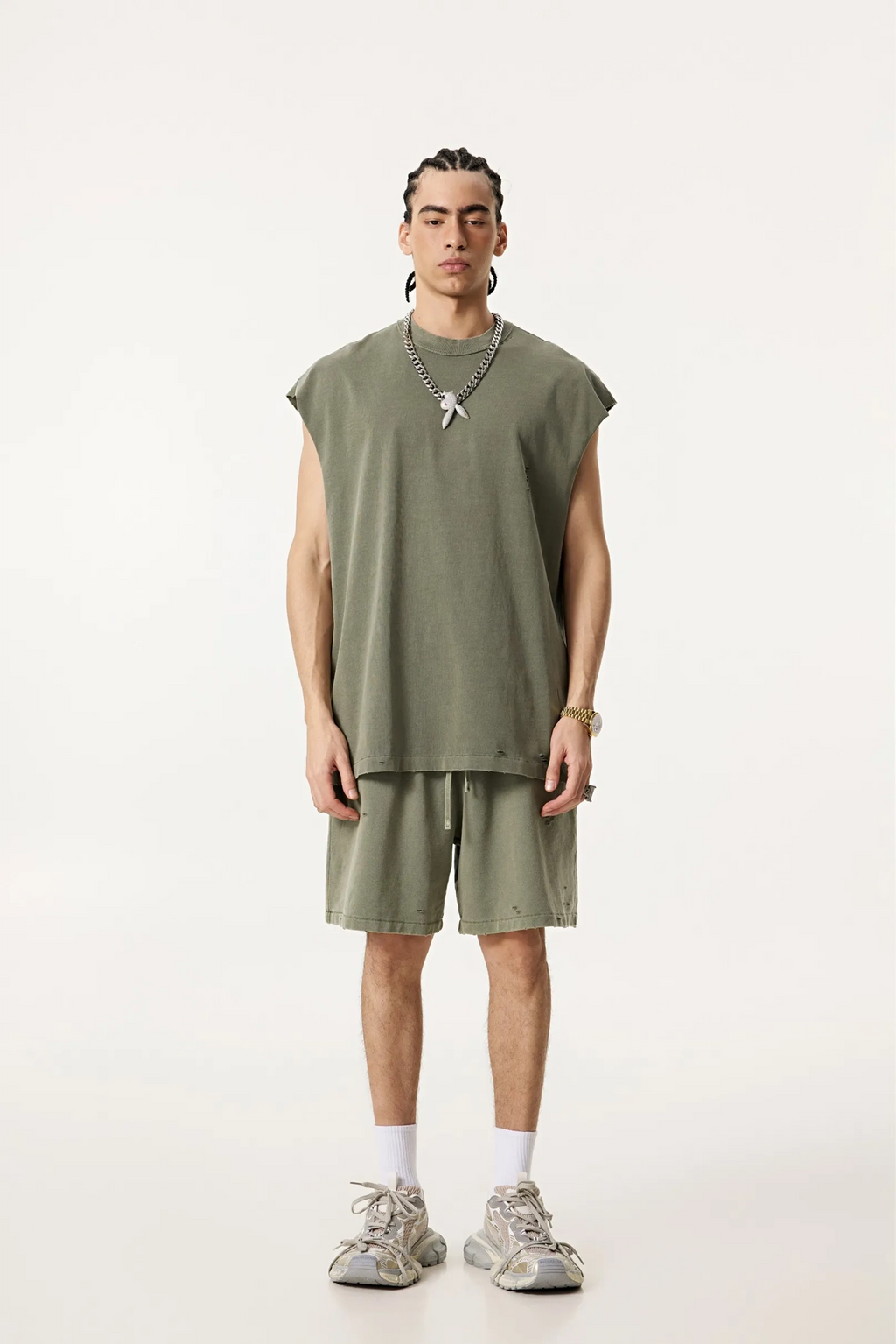 Person wearing a green sleeveless top and shorts set on a white background