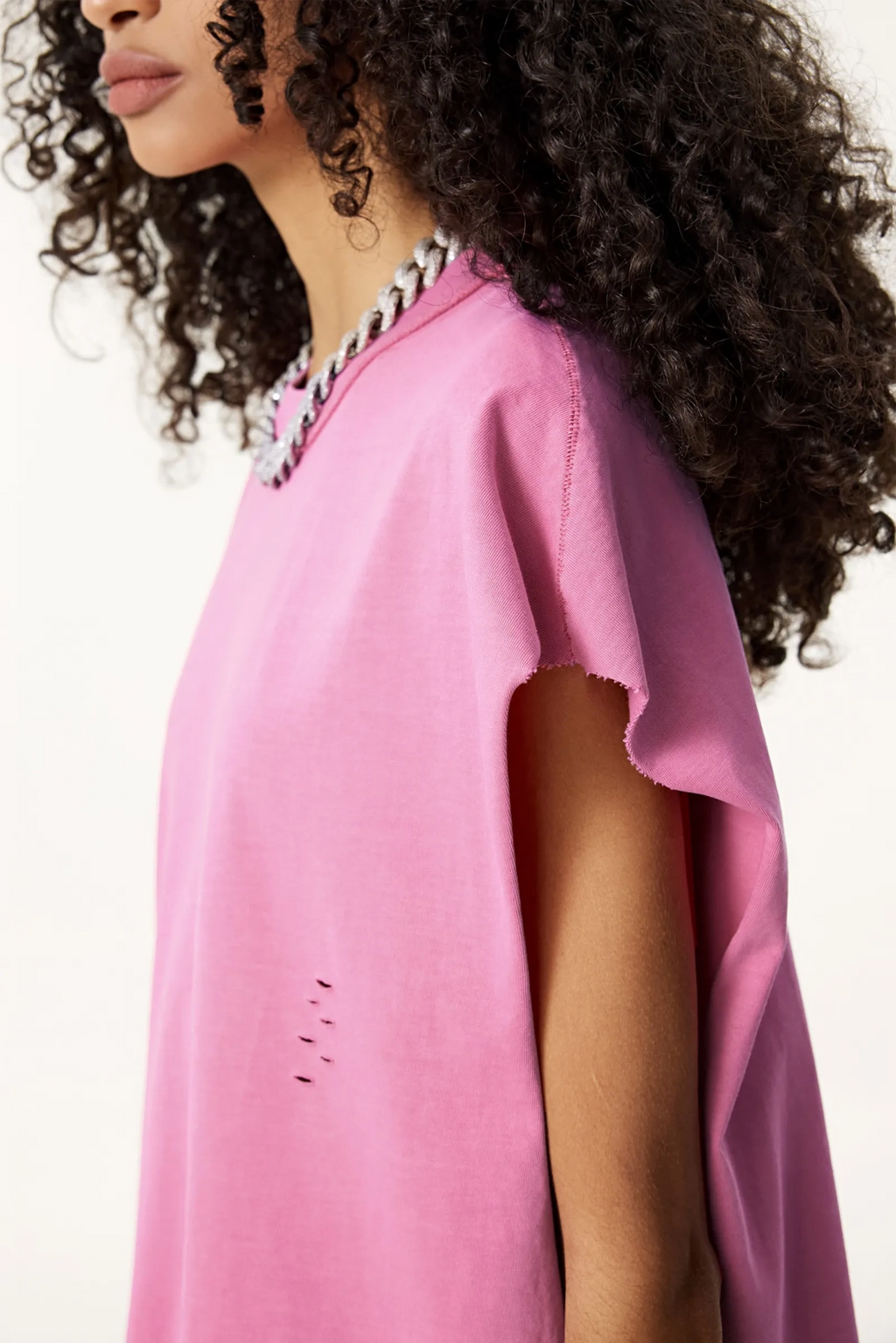 Person wearing a pink poncho with a white background