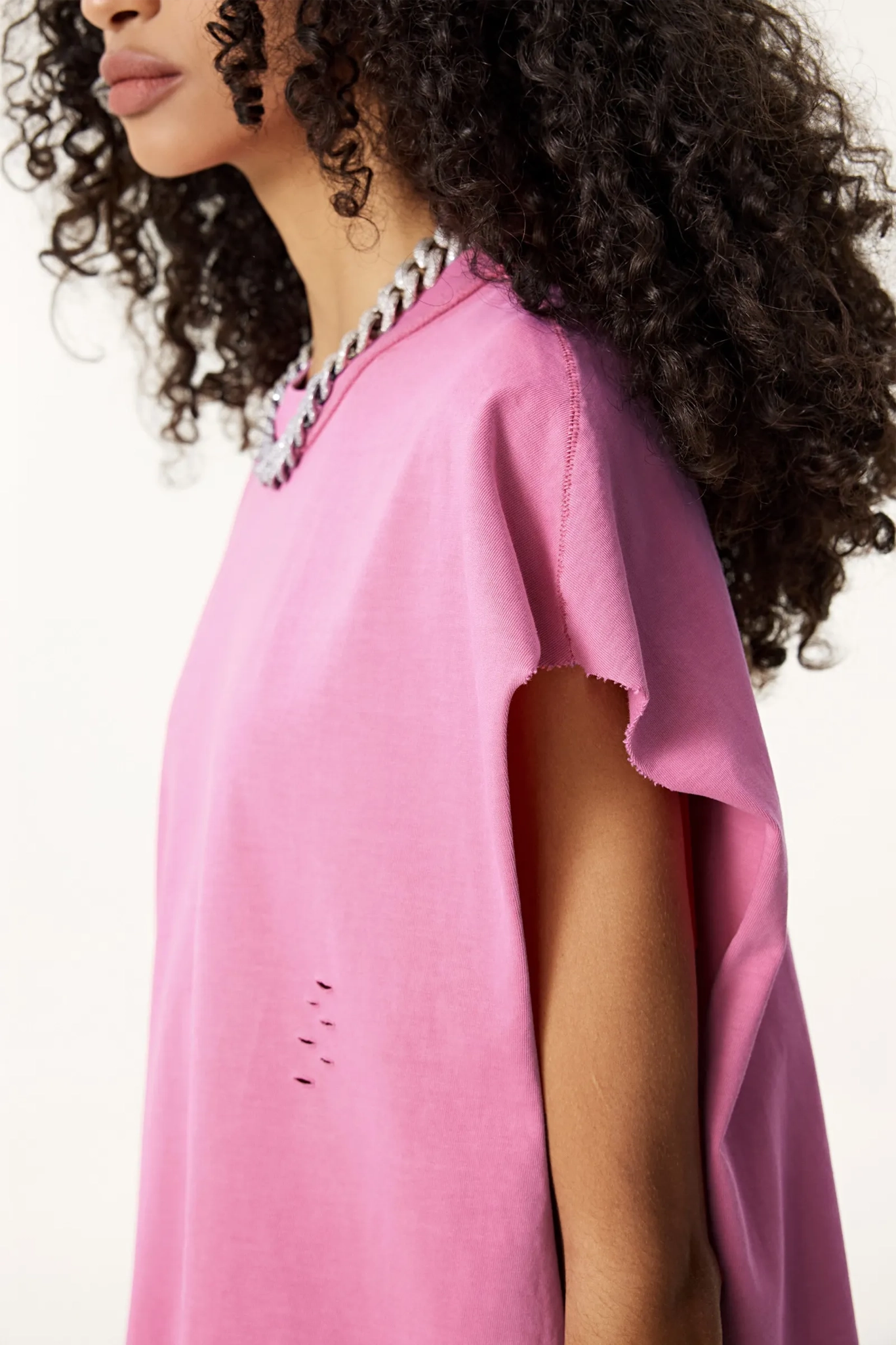 Person wearing a pink poncho with a white background