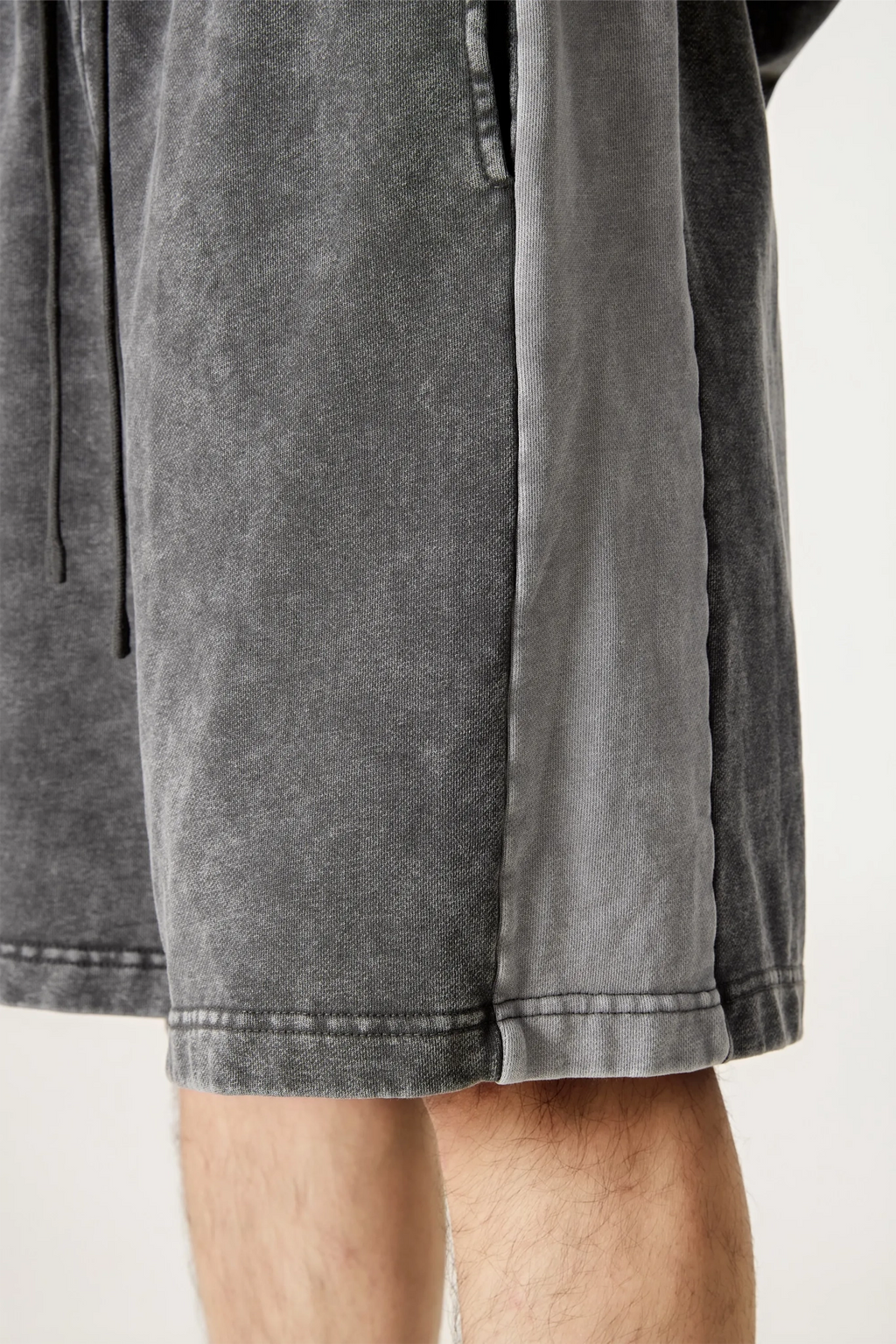 Gray shorts worn by a person on a white background
