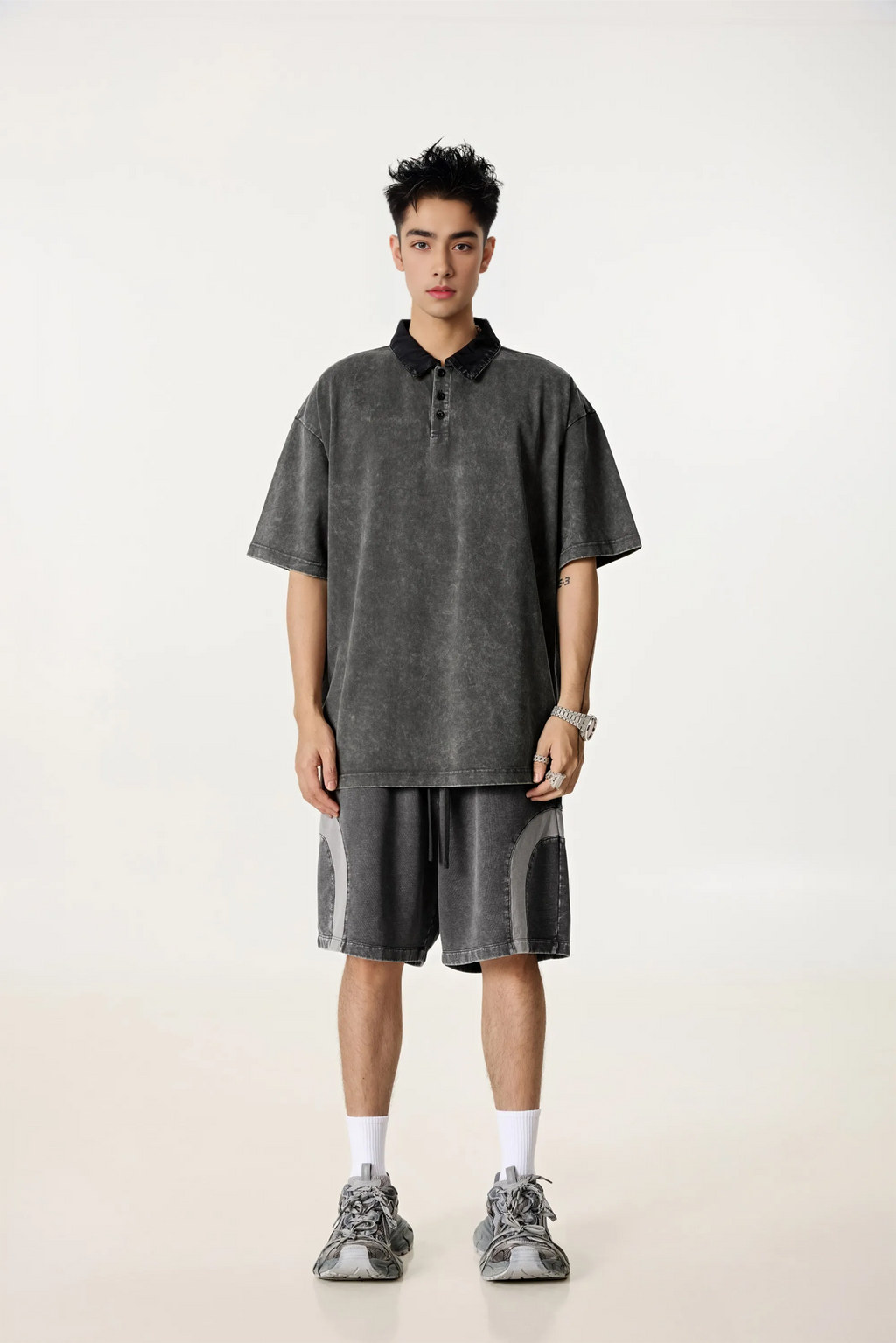 Person wearing a gray polo shirt and shorts set on a white background