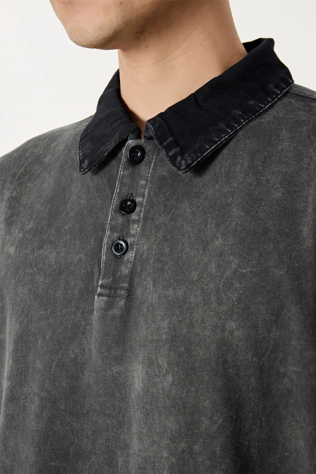 Close-up of a person wearing a dark gray polo shirt with a black collar.