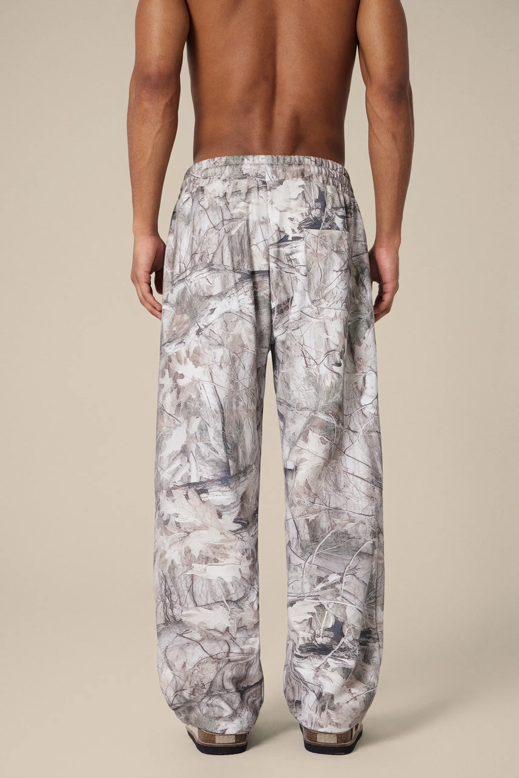 Man wearing patterned pants on a beige background