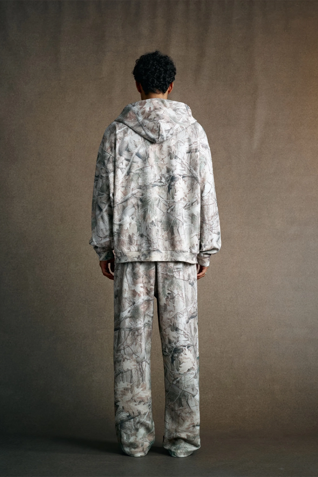 Person wearing a matching camouflage outfit against a plain background