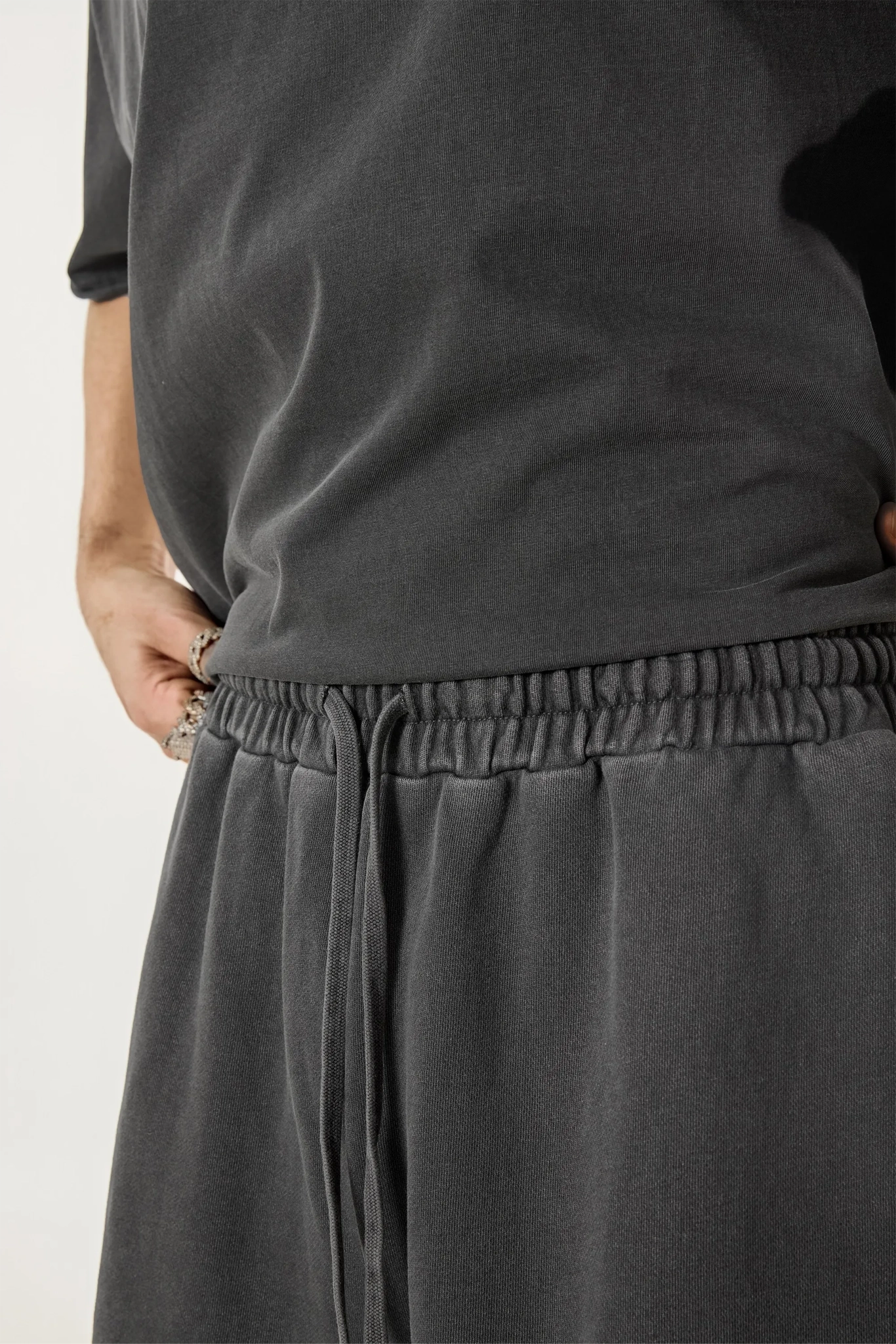 Person wearing a dark gray outfit with a focus on the pants.