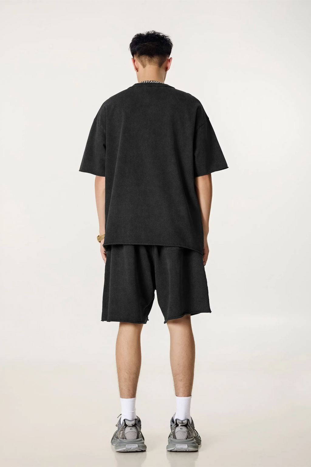 Person wearing a black t-shirt and shorts set on a white background