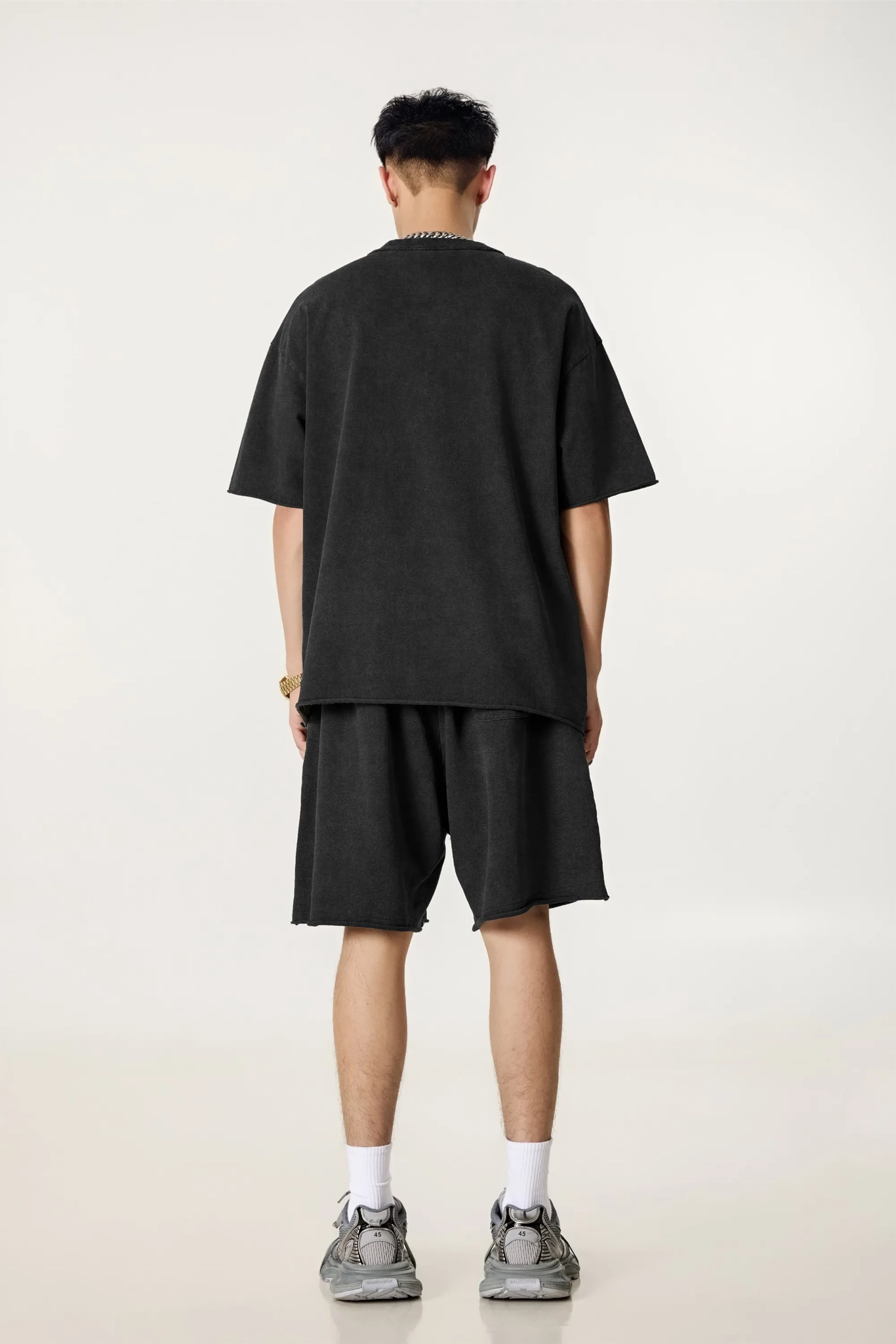 Person wearing a black t-shirt and shorts set on a white background