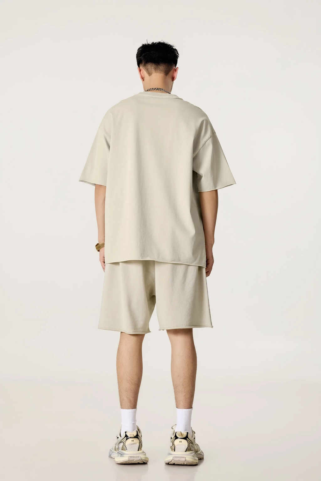 Person wearing a beige outfit on a white background