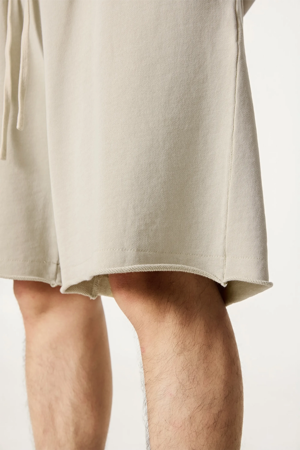 Beige shorts worn by a person on a plain background