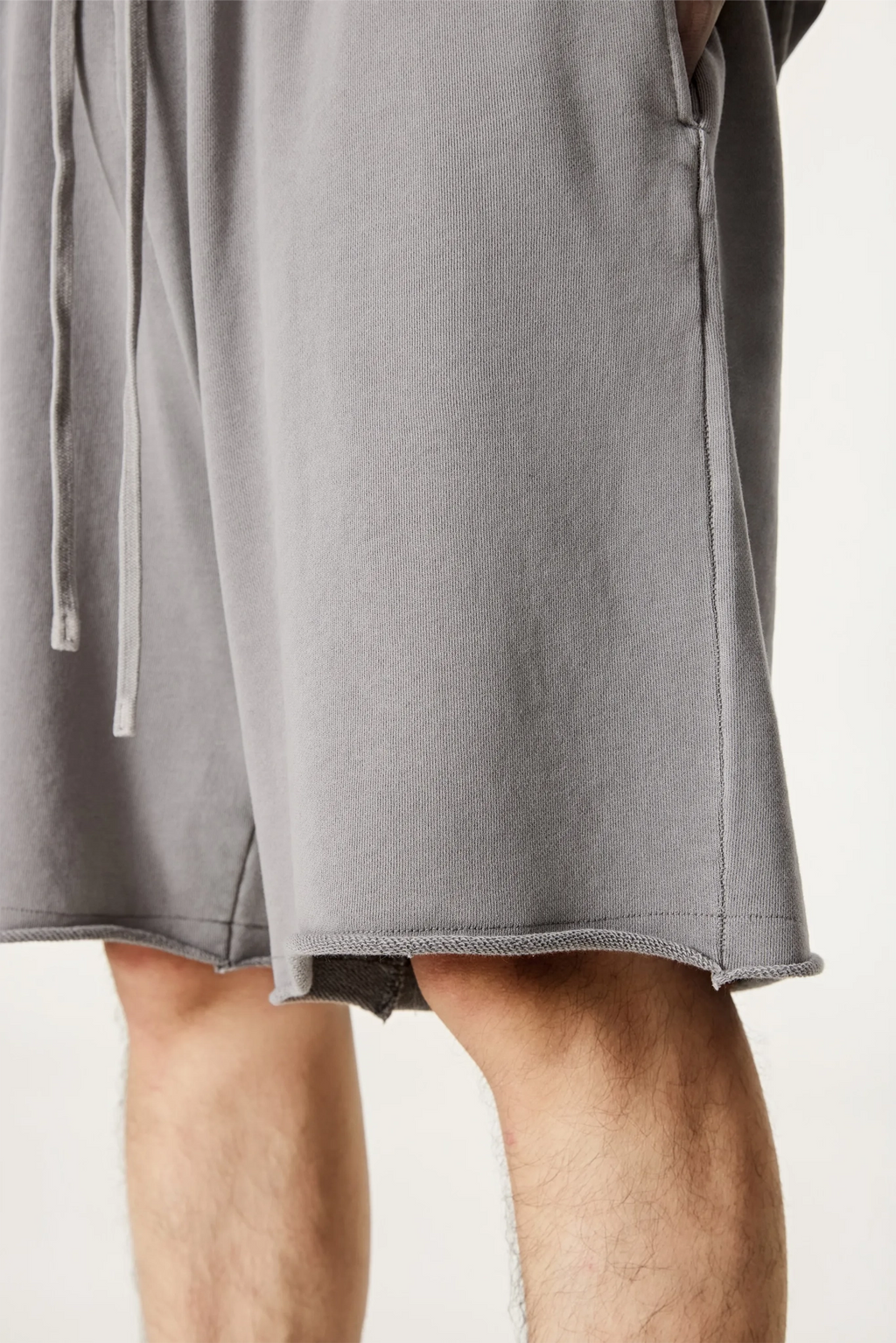 Gray shorts worn by a person on a plain background