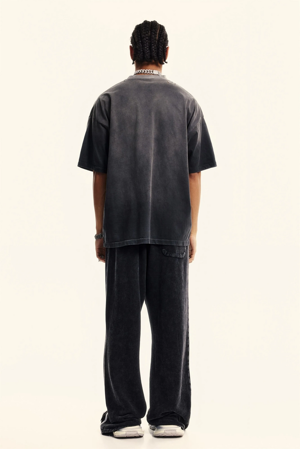 Person wearing a dark gray t-shirt and pants on a white background