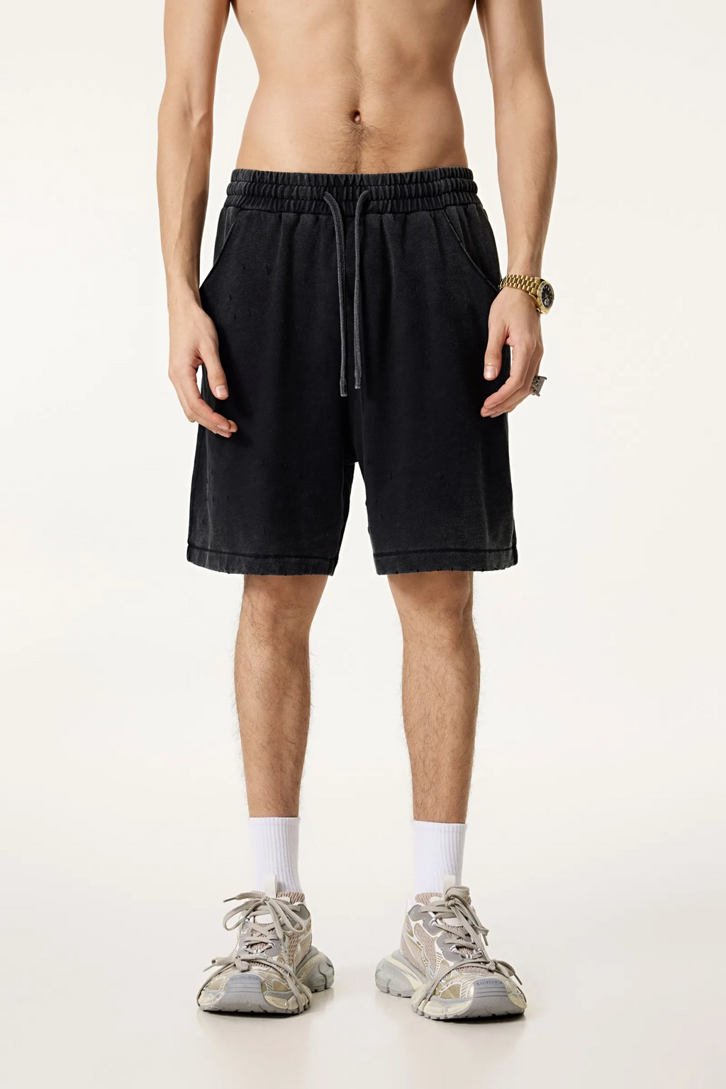 Person wearing black shorts on a white background