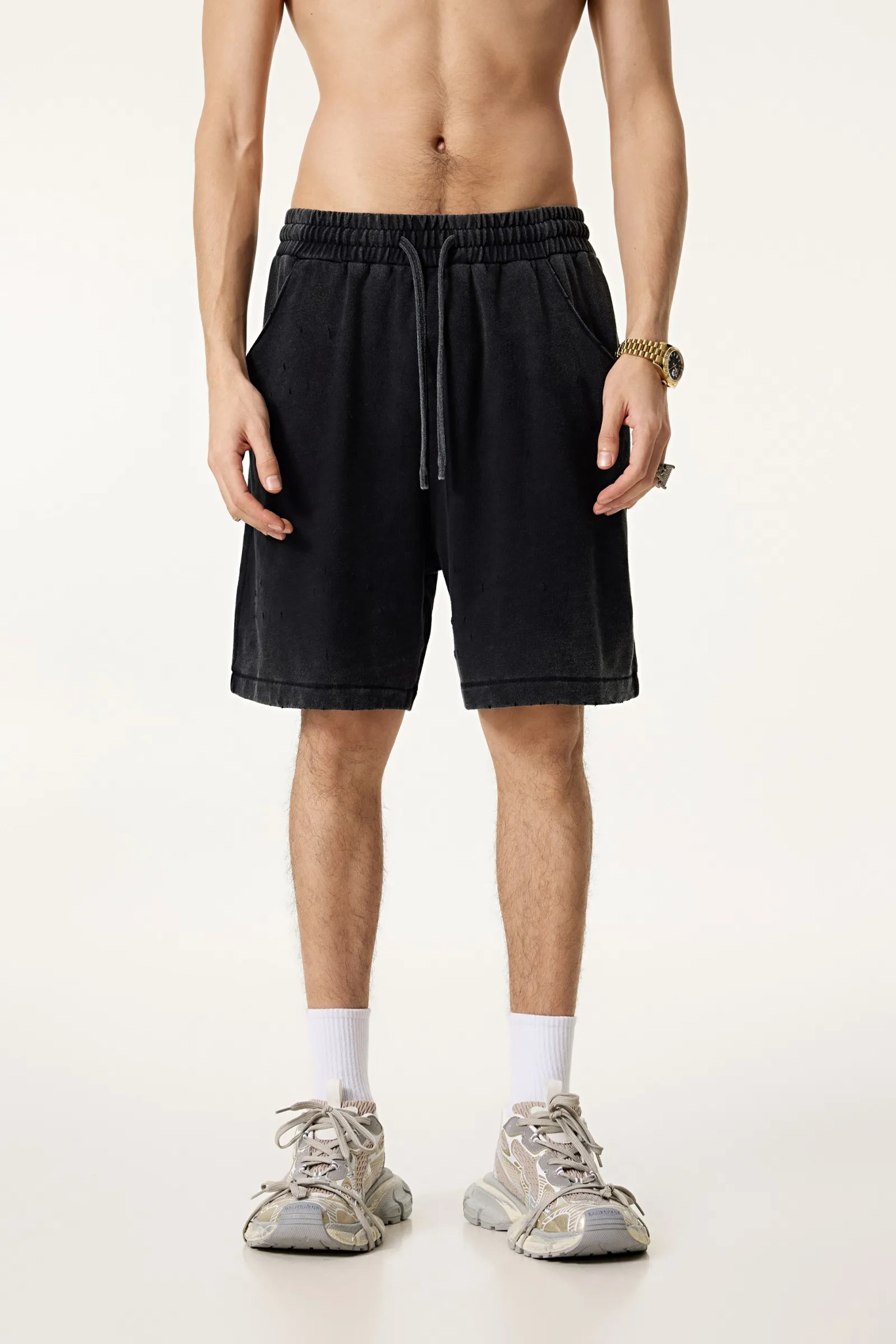 Person wearing black shorts on a white background