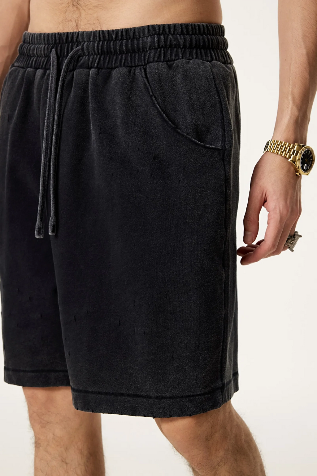 Black shorts worn by a person on a plain background