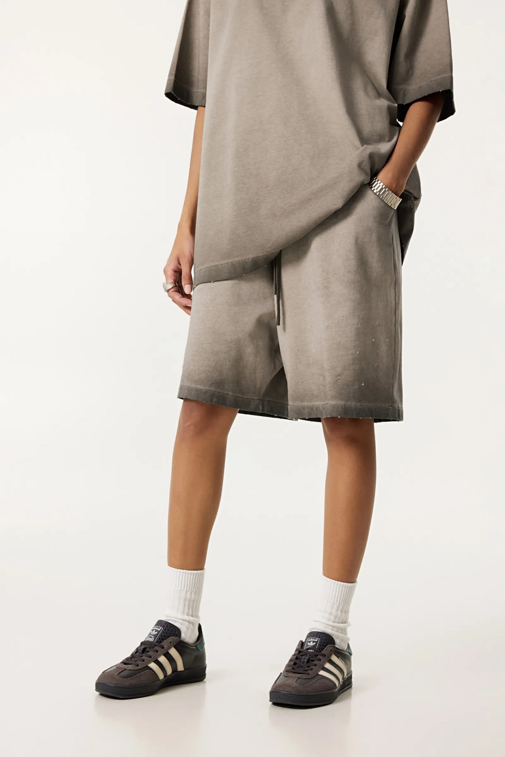 Person wearing a gray dress with a white background