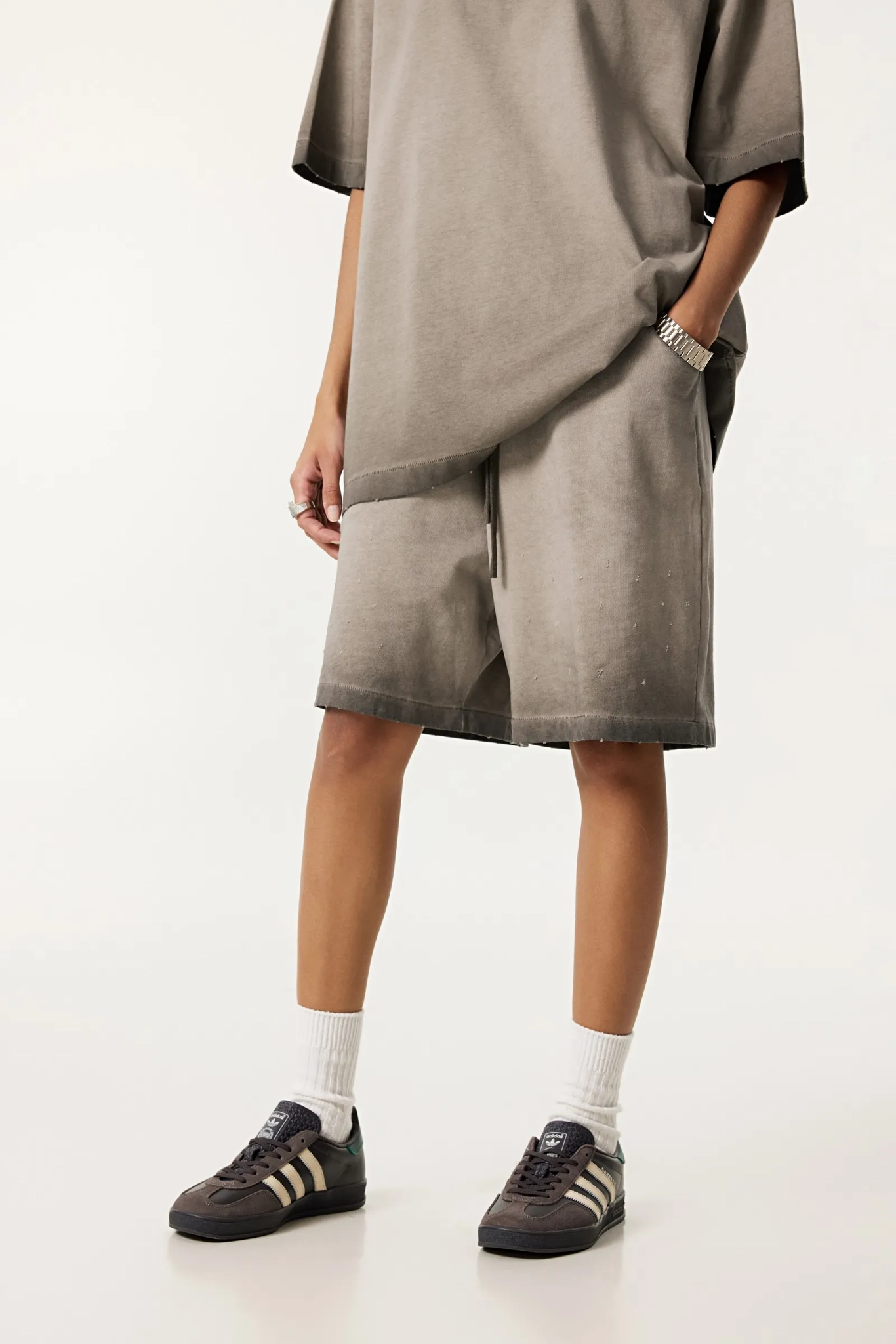 Person wearing a gray dress with a white background