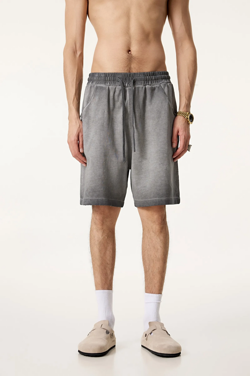 Man wearing gray shorts on a white background