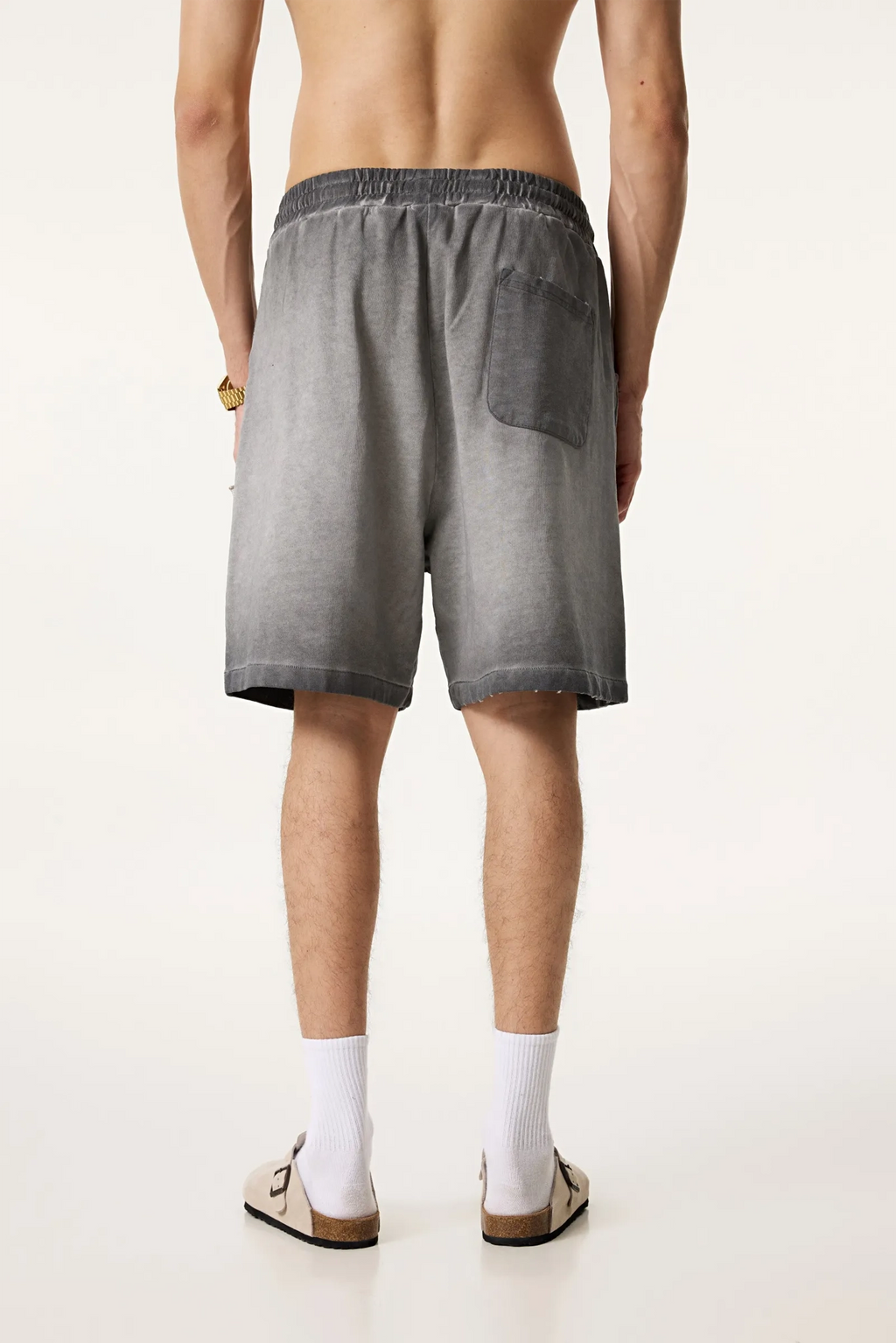 Person wearing gray shorts on a white background