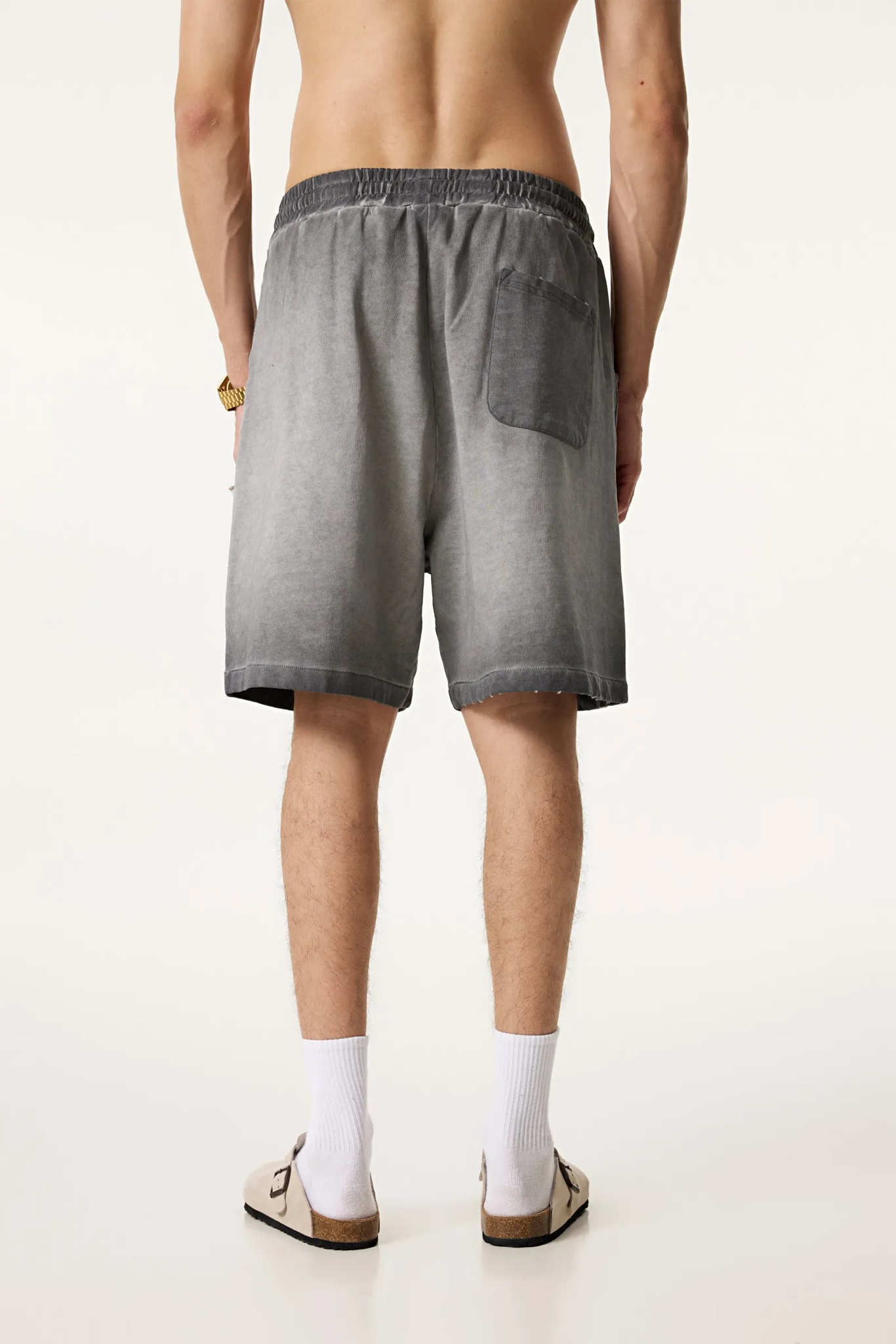 Person wearing gray shorts on a white background