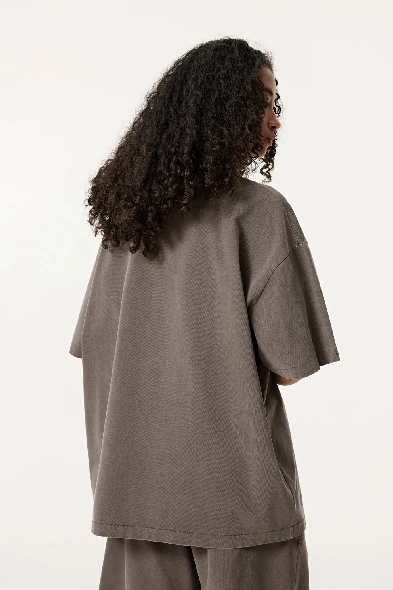 Person wearing a brown outfit on a white background