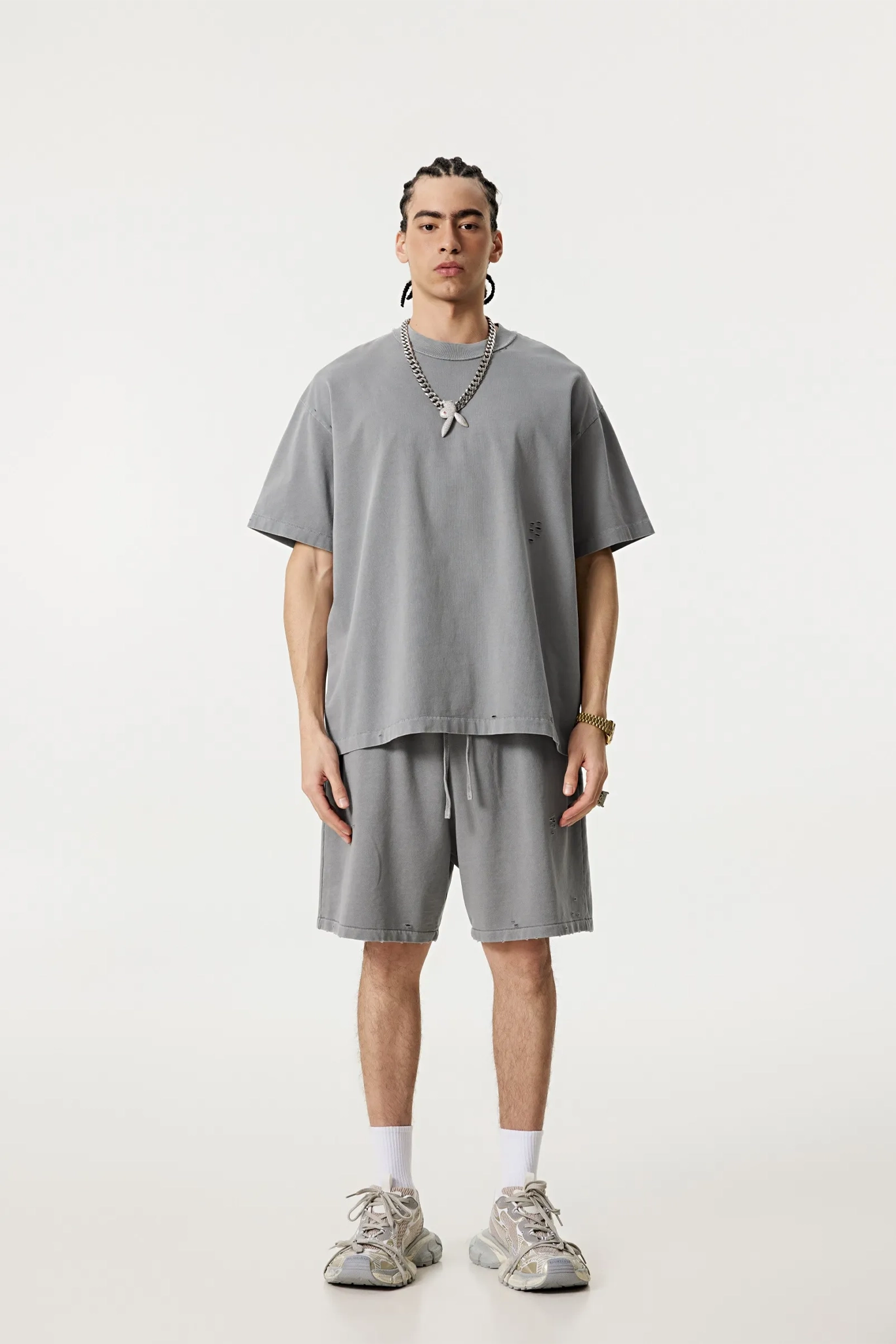 Person wearing a gray t-shirt and shorts set on a white background