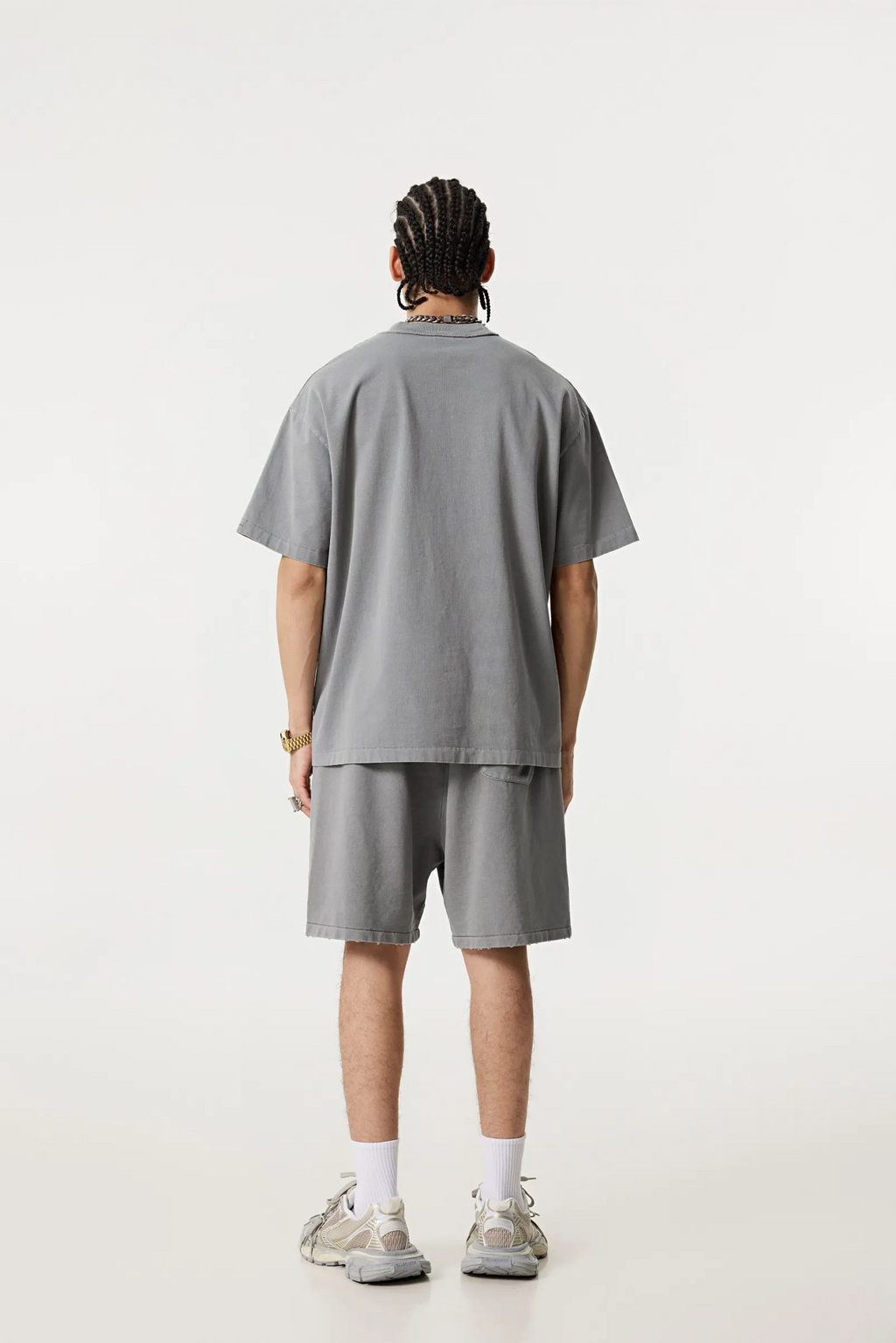 Person wearing a gray t-shirt and shorts set on a white background