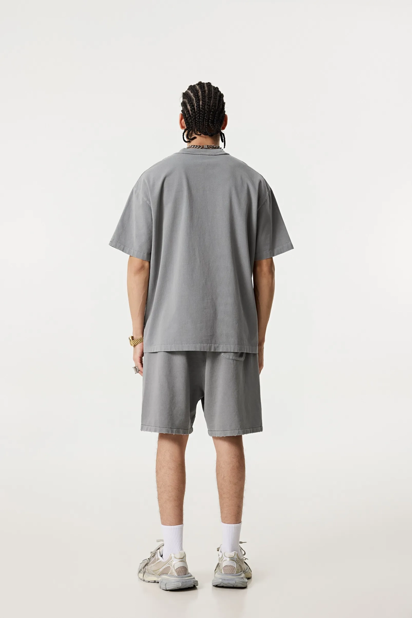 Person wearing a gray t-shirt and shorts set on a white background