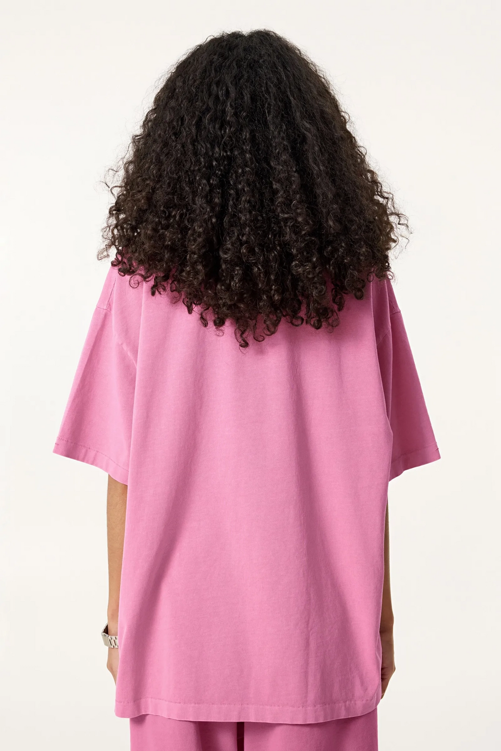 Person wearing a pink outfit with a plain background