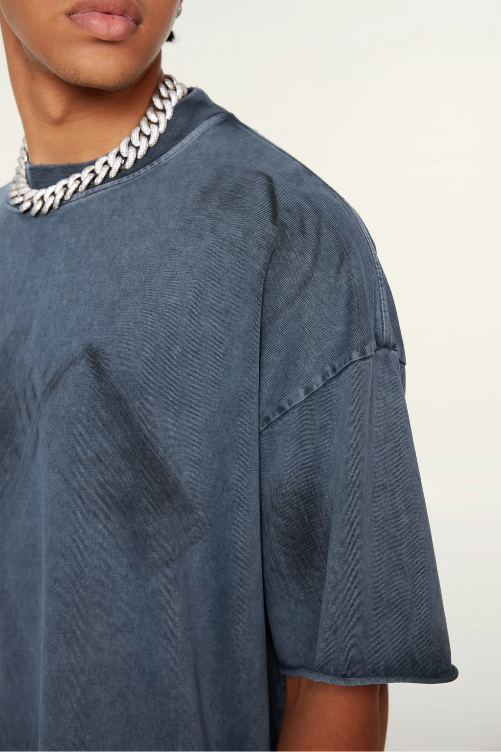 Person wearing a blue oversized t-shirt with a white background