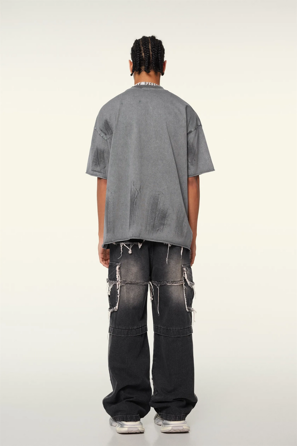 Person wearing a gray t-shirt and black pants on a white background