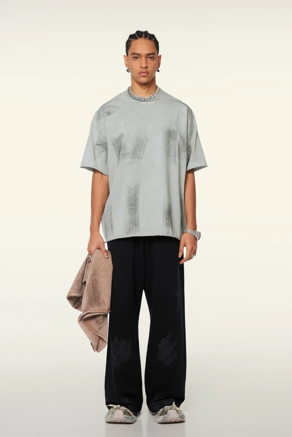 Person wearing a light gray t-shirt and black pants on a white background