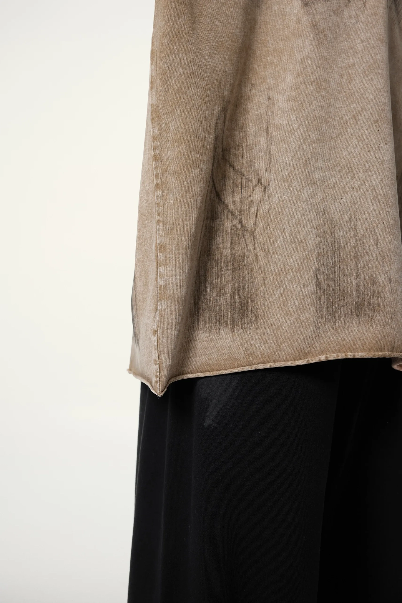 Close-up of a beige garment with visible wear on a white background