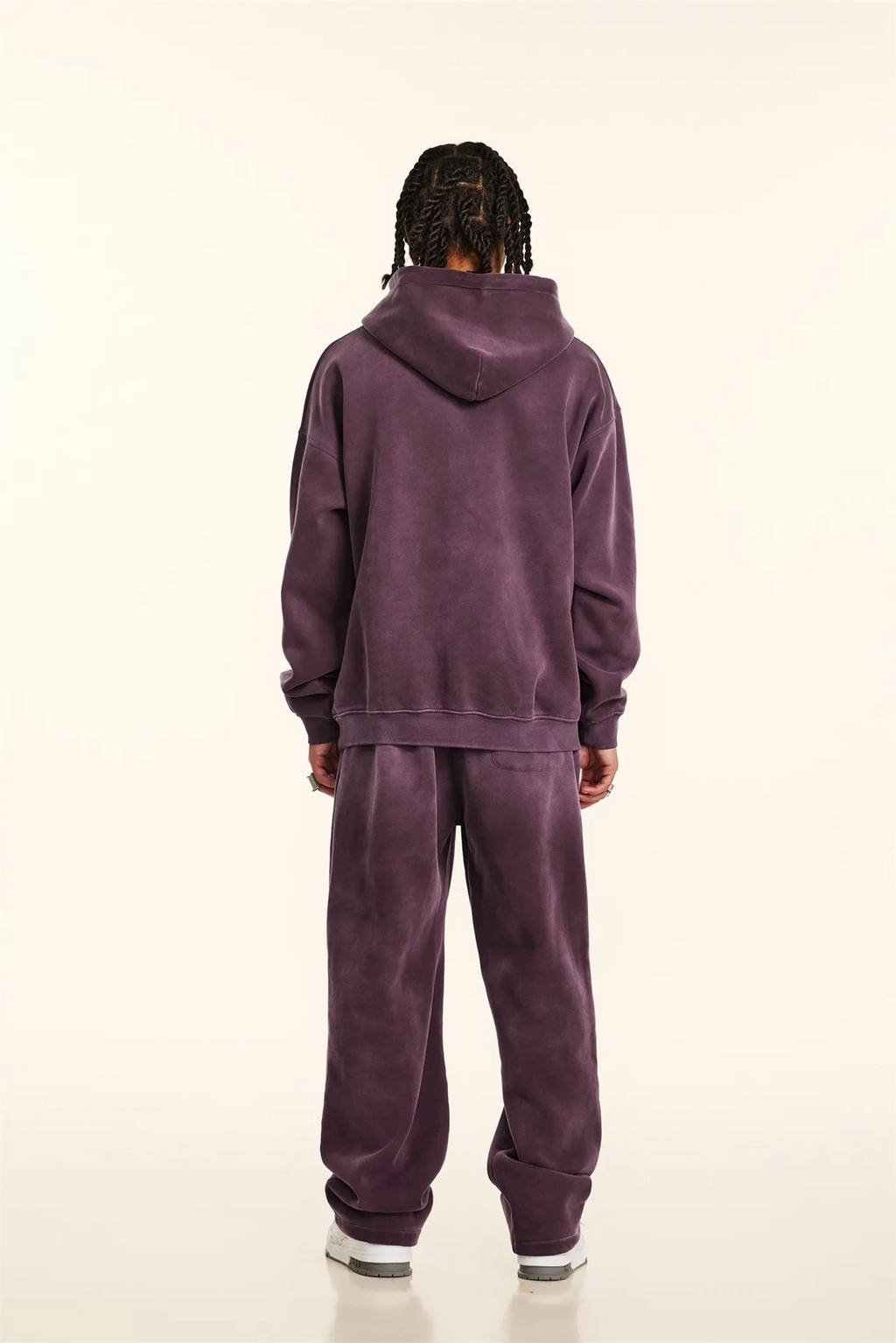 Person wearing a purple tracksuit on a white background