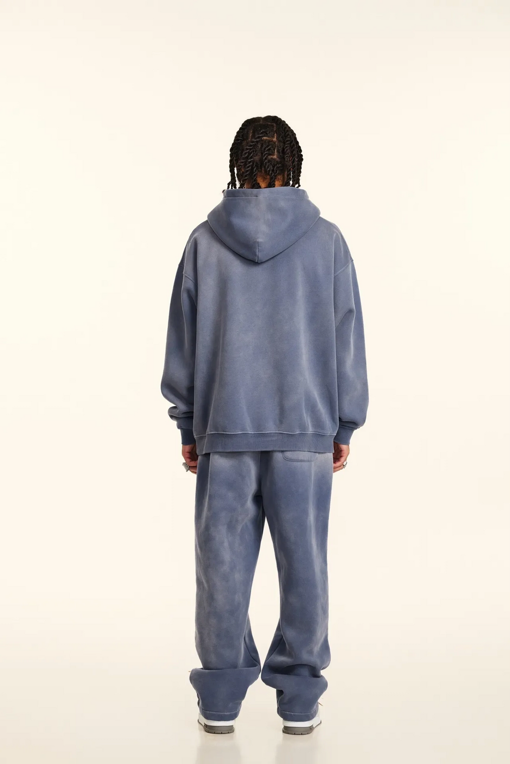 Person wearing a blue tracksuit standing against a white background