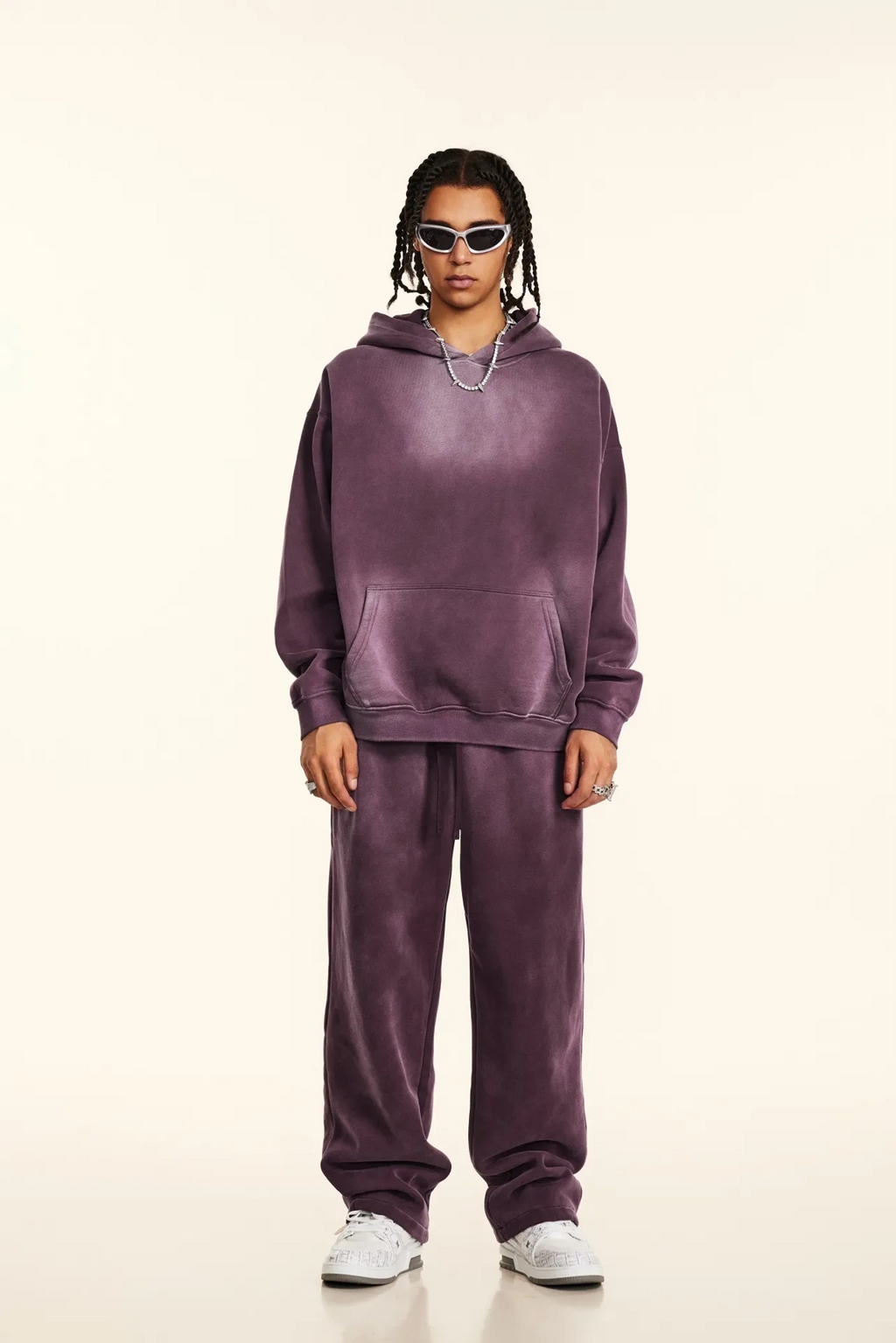 Person wearing a purple tracksuit on a beige background