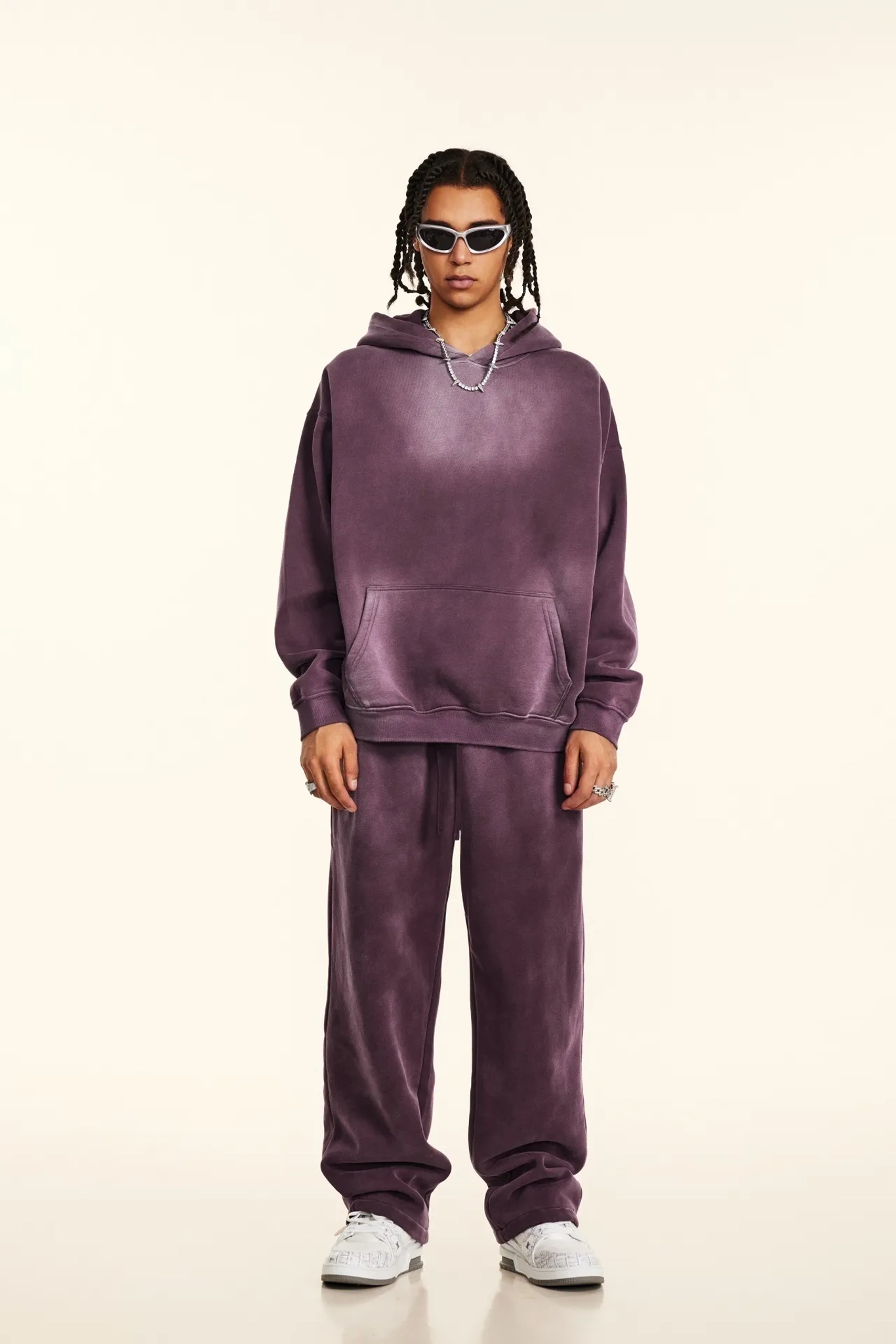 Person wearing a purple tracksuit on a beige background