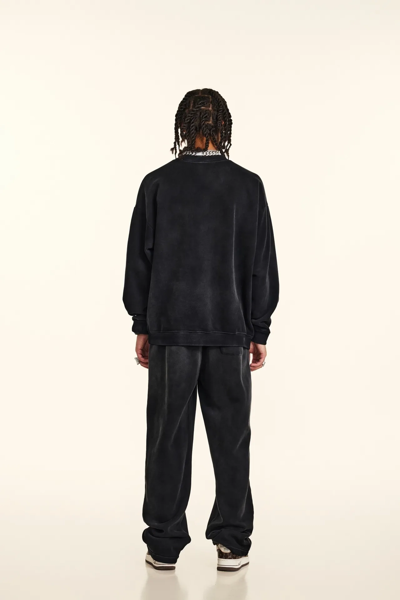 Person wearing a black tracksuit on a white background